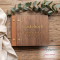 Holz-Gästebuch mit gravierten Namen Marie und Lukas und Hochzeitsdatum auf einem Holztisch